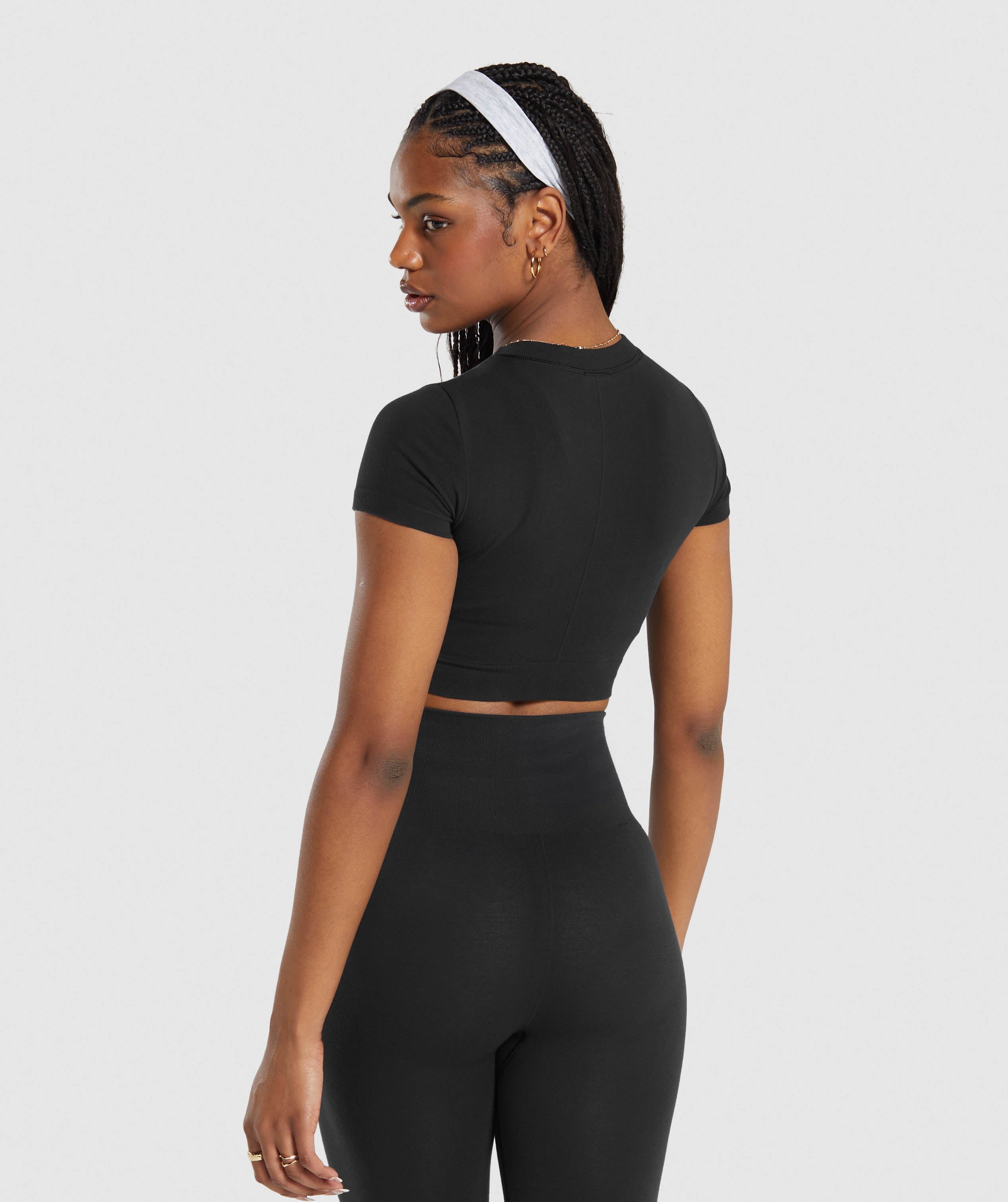 net leggings, black shorts and waist-cropped silver sleeveless top