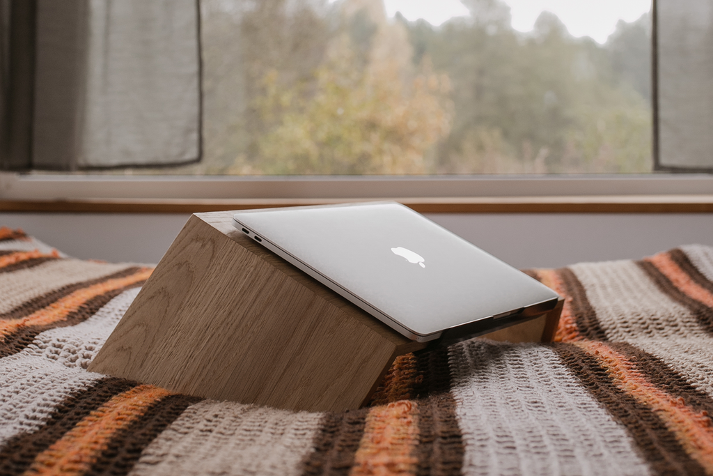 closed laptop on a wooden stand