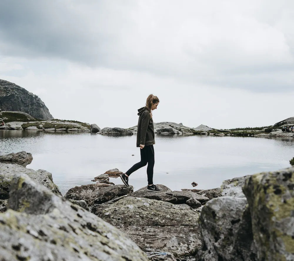 woman walking beside lake