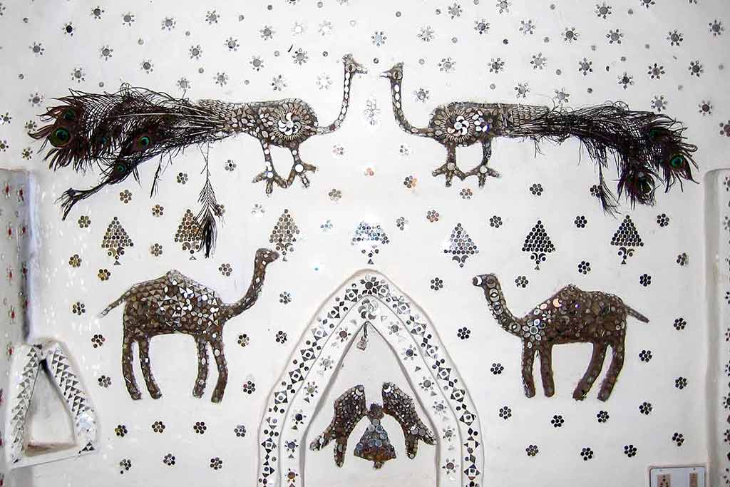 Mirrored & sequinned peacock images on a guest house wall in Jhunjhunu