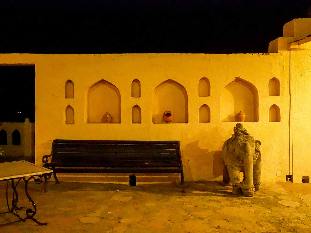 Courtyard with niches, simple clay pots and an elephant at Neemrana