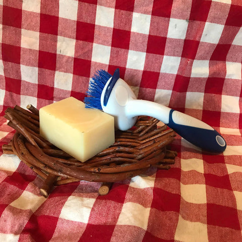 a bar of solid dish soap sits on a willow basket soap dish with a scrub brush