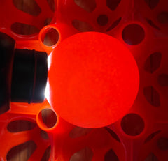 looking down on to the end of an egg on a red egg collecting tray which is being illuminated by an egg candler. a faint circle can be seen that takes up only a small part of the top of the egg
