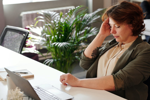 woman with headache after taking caffeine to focus