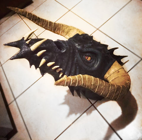 black paper mache dragon with golden eyes