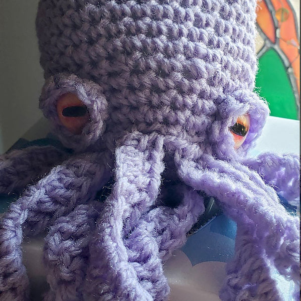 purple crochet octopus with orange glass button eyes