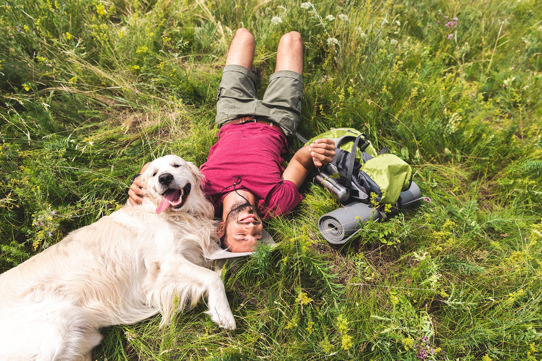 Dog and Pet Parent laying in grass after hike