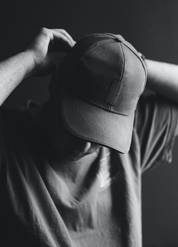 A grayscale picture of a man wearing a cap