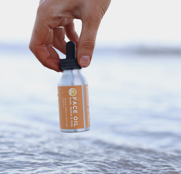 The lowdown on free radicals, antioxidants and your skin. An image of SunButter face oil being held above seawater.