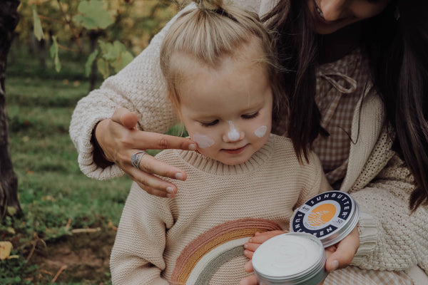 Things to look for in kids sunscreen - a women applies sunscreen to a small toddler 