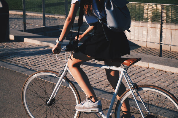 How can I reduce my emissions? A woman rides a bike in the sunshine