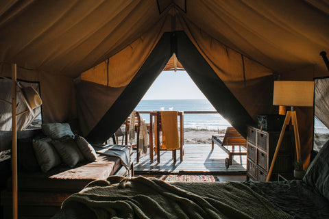 The interior of a luxury tent, looking out towards a beach