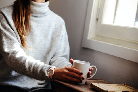 Woman drinking Tea looking out window