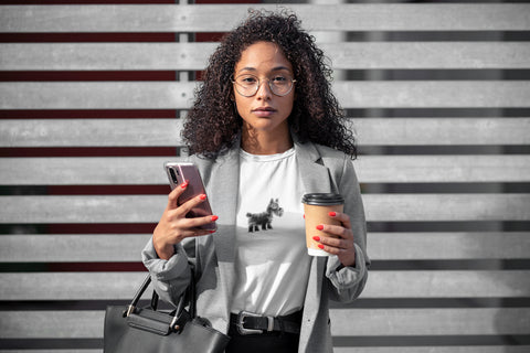 Woman holding a drink and bag whilst wearing an organic cotton t shirt