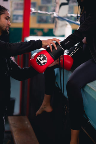 Man fitting a glove onto someone else