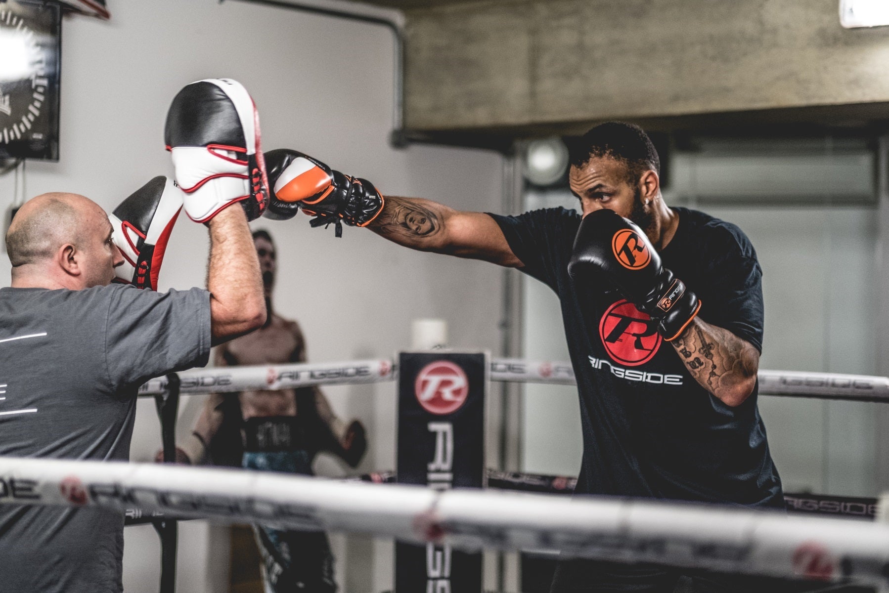 Boxer in ring hitting pads