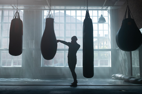 Lady and punchbag silhouettes in a gym