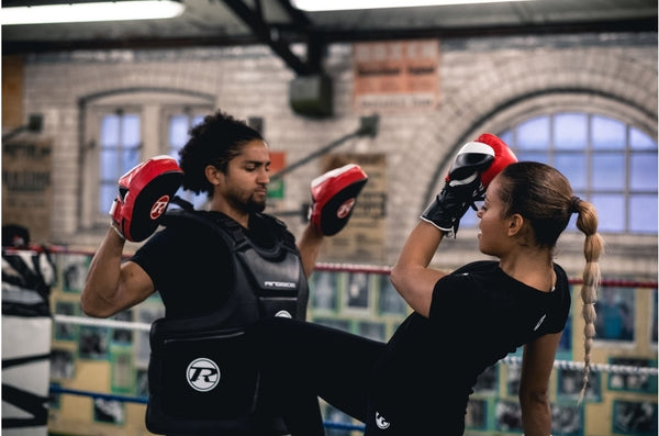 Girl kneeing trainer who is wearing coach guard