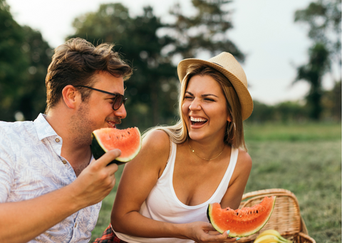 Couple having picnic and eating watermelon outdoors