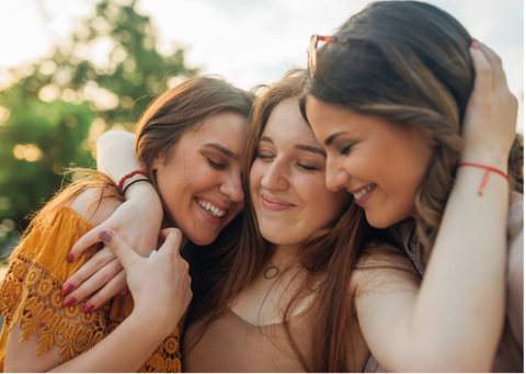 Three friends hugging and smiling