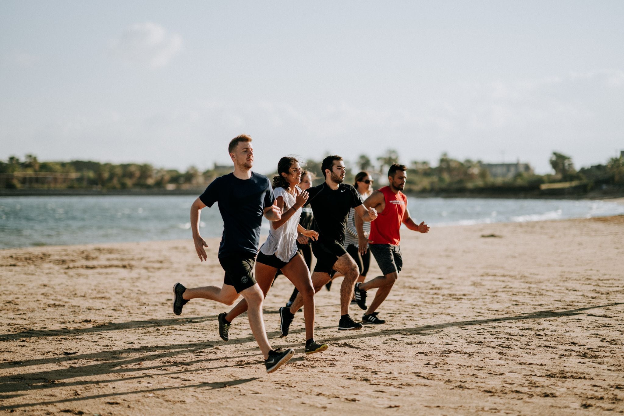 Group of people running in the beach.