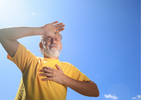 Man struggling with the intense sun, suffering from heatstroke outdoors