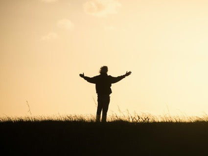 Person with open arms in a field