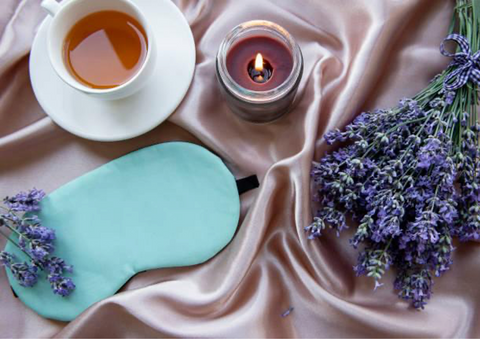 Lavender, tea, and candle on a bed.