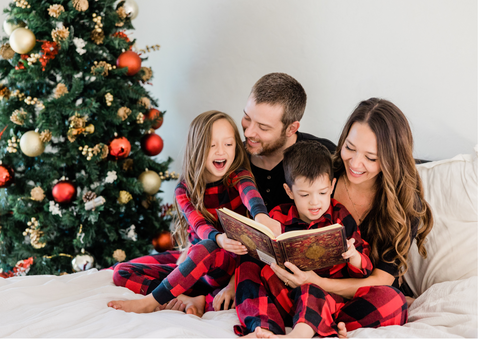 Family reading a book near the christmas tree