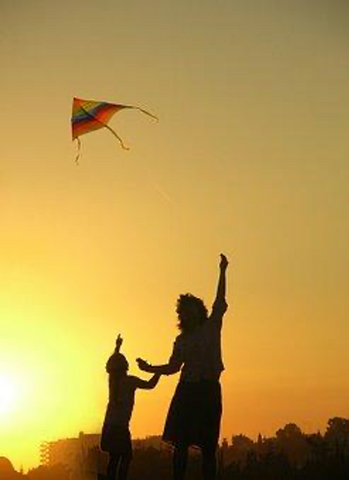 Woman and kid playing with a kite paper