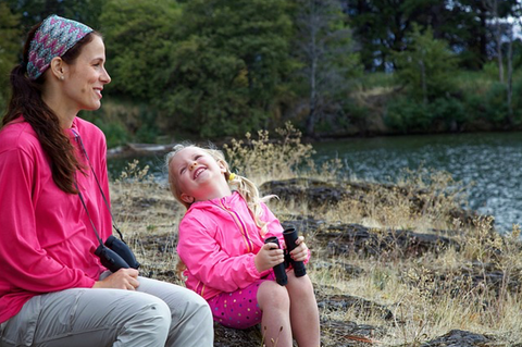 Mother with her daughter outdoors laughing.