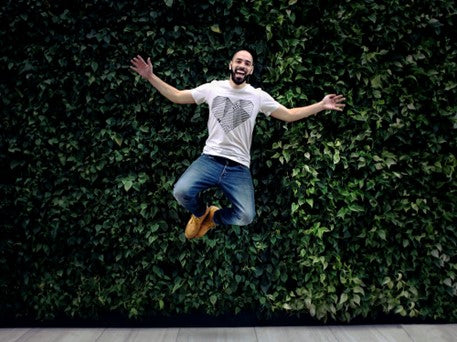 man jumping with arms open and smiling