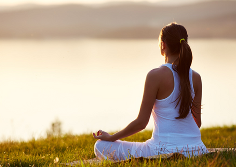 Woman meditating outdoors.