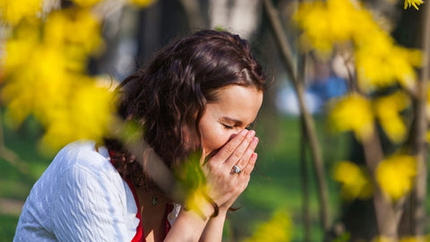 Woman sneezing outdoors