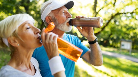 Senior couple drinking water outdoors