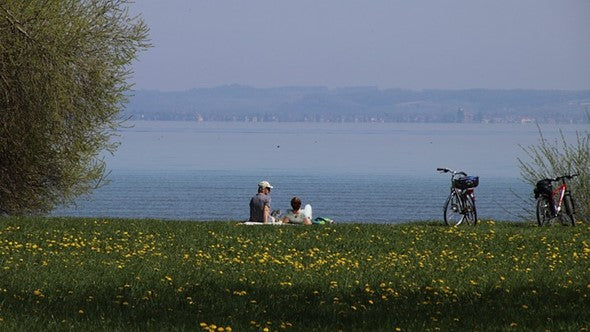 Couple lying in grass next to a river