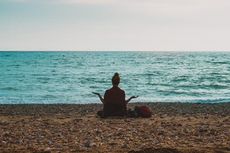 Woman meditating at the beach