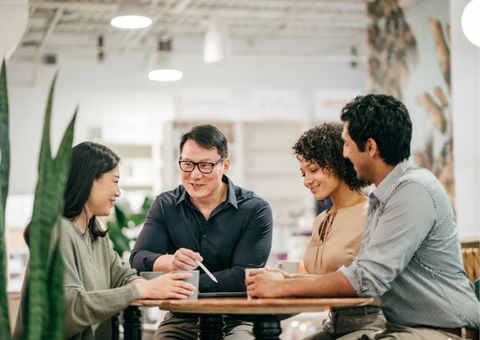 Happy work team meeting at a table.