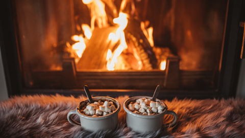 Mugs of hot chocolate in front of the fireplace