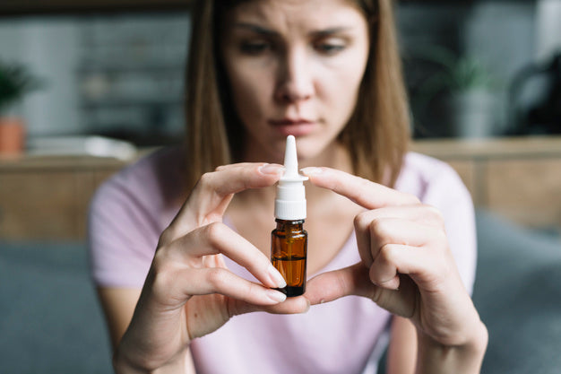 Woman holding nasal spray