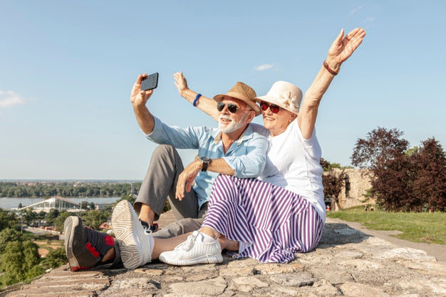 Senior couple taking a selfie outdoors.