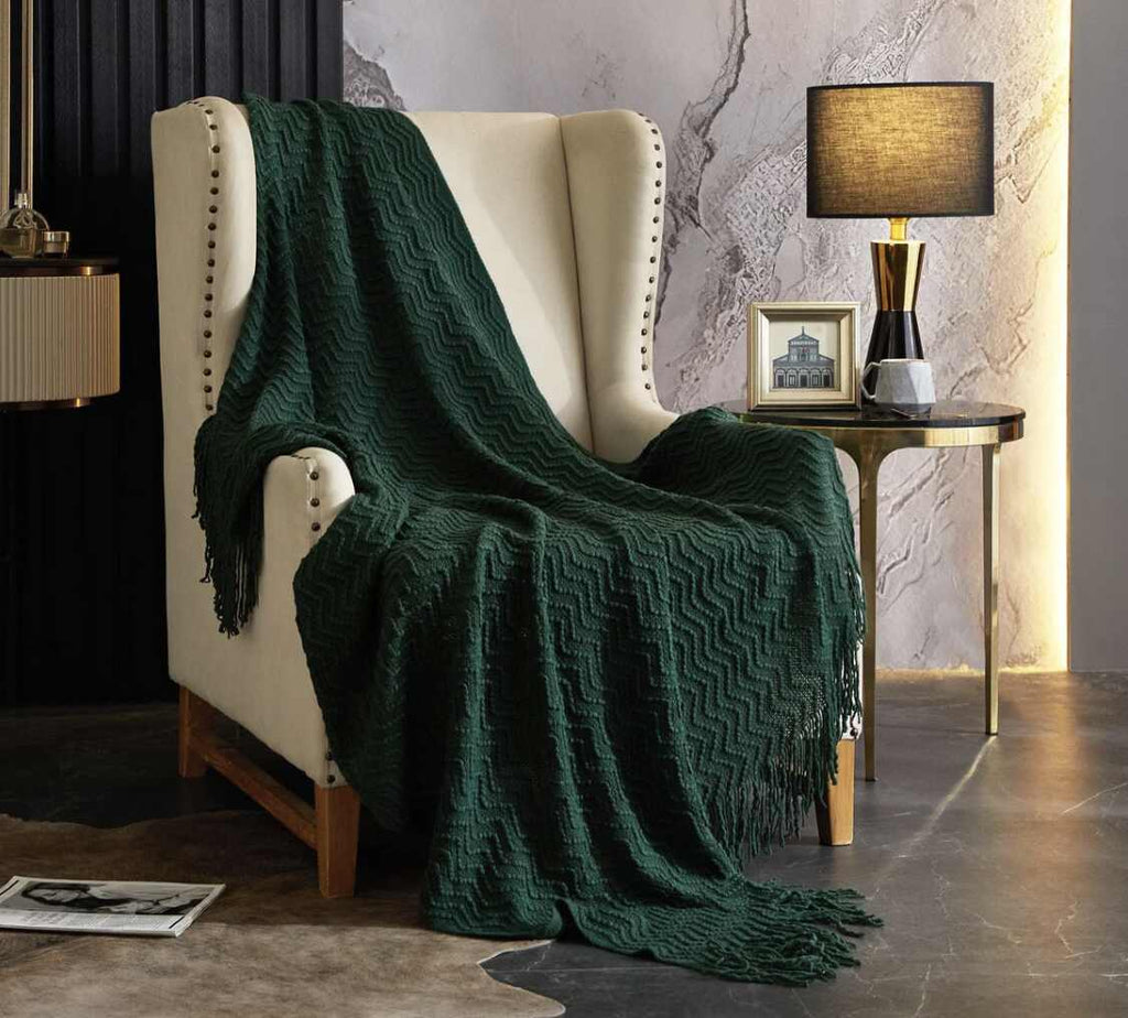 A white chair with a soft green throw blanket