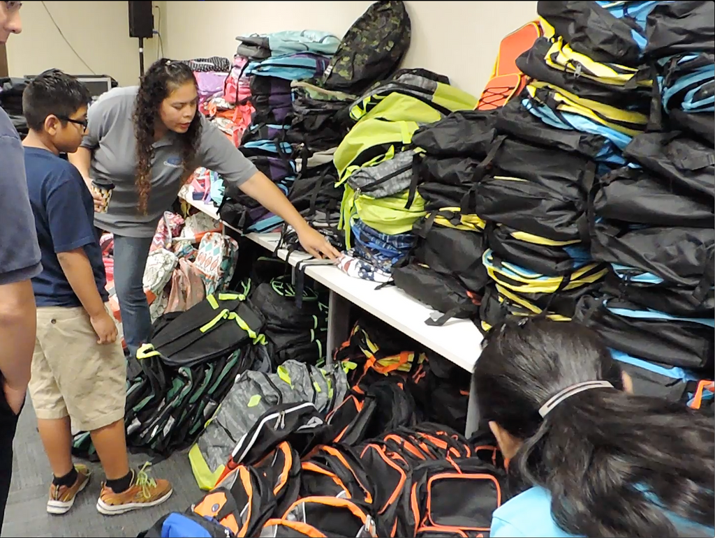Coronado DC workers give schoolkids backpacks
