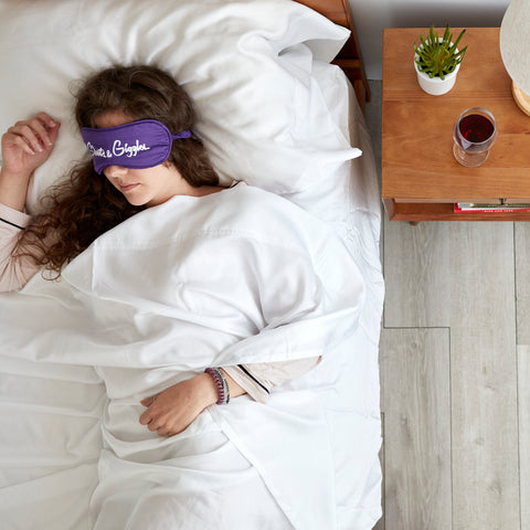 Woman sleeping in bed wearing eye mask