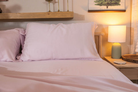 a bed with pink (orchid) sheets