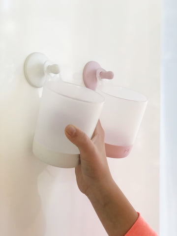 2 hanging cups with girls hand reaching for them