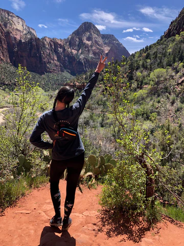 Sherpani staff member hiking in Zion National Park in Utah. She is wearing Sherpani belt bag, the Hyk in Chromatic