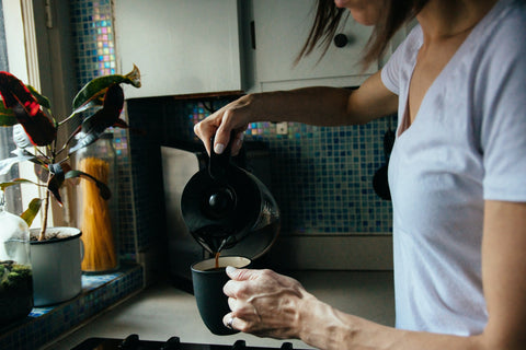 A woman pouring her morning cup of coffee