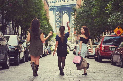 Three female friends shopping together and walking down the street