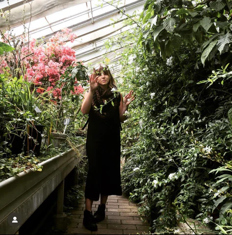 A blonde woman looking at the plants in Copenhagen's Botanical Gardens.